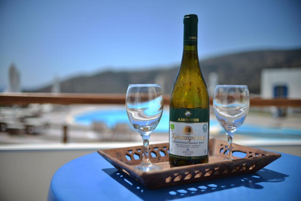 a bottle of wine and two glasses on a table at Amorgion Village in Katapola