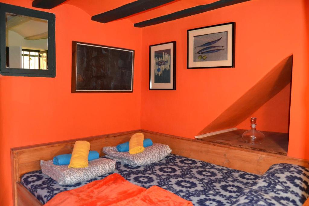 a bedroom with orange walls and a bed with pillows at Casa LOS ANGELES in Villajoyosa