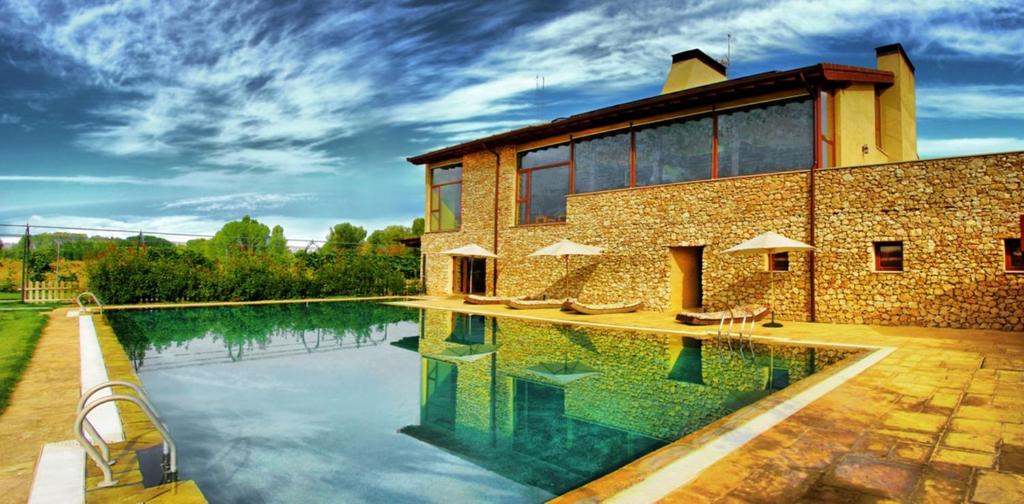 uma casa com uma piscina em frente em Hotel Rural y SPA Kinedomus Bienestar em Aranda de Duero