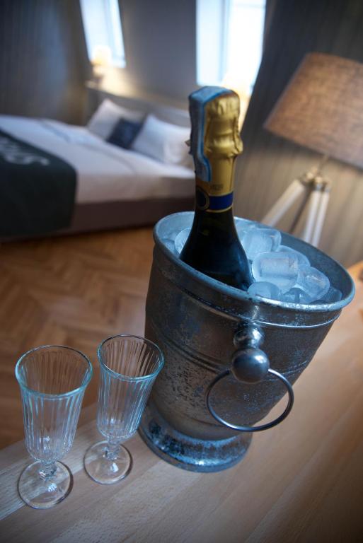 a bottle of champagne in a ice bucket on a table with two glasses at Smokvica Dorćol B&B in Belgrade