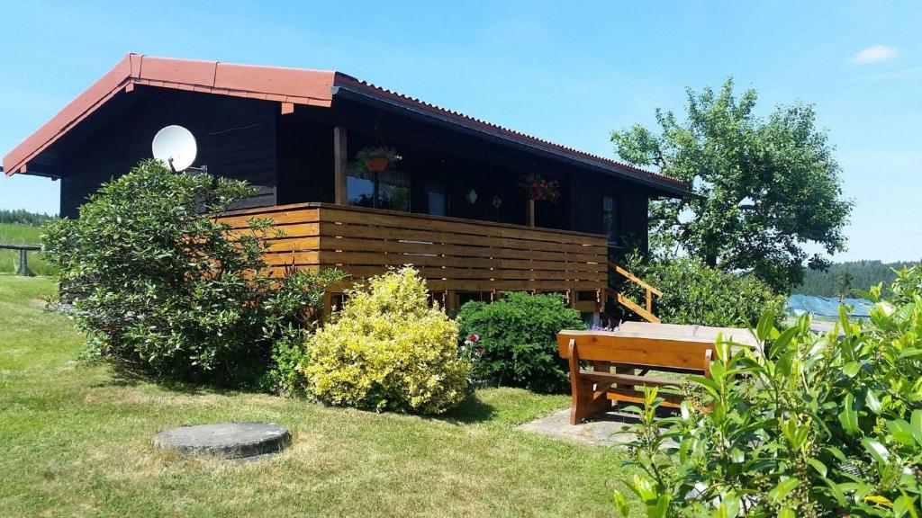 ein Holzhaus mit einer Bank davor in der Unterkunft Ferienhaus Schallerhof in Kupferberg
