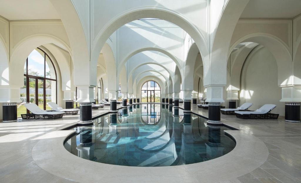 a lobby with a pool of water in a building at Four Seasons Hotel Tunis in Gammarth