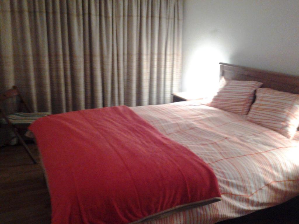 um quarto com uma cama com um cobertor vermelho em Covelo no Porto