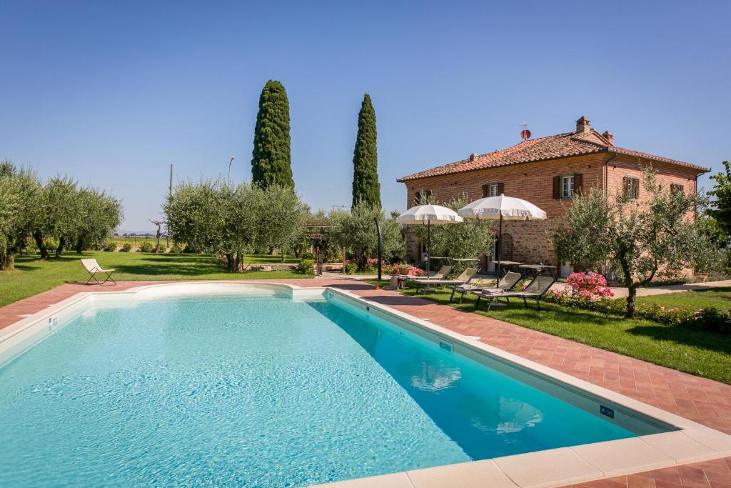 una piscina di fronte a una casa di Villa Il Giardino di Diana a Cortona