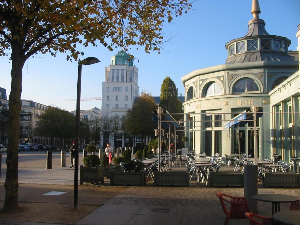 a building with a lot of tables and chairs at Le Charleston in Chessy