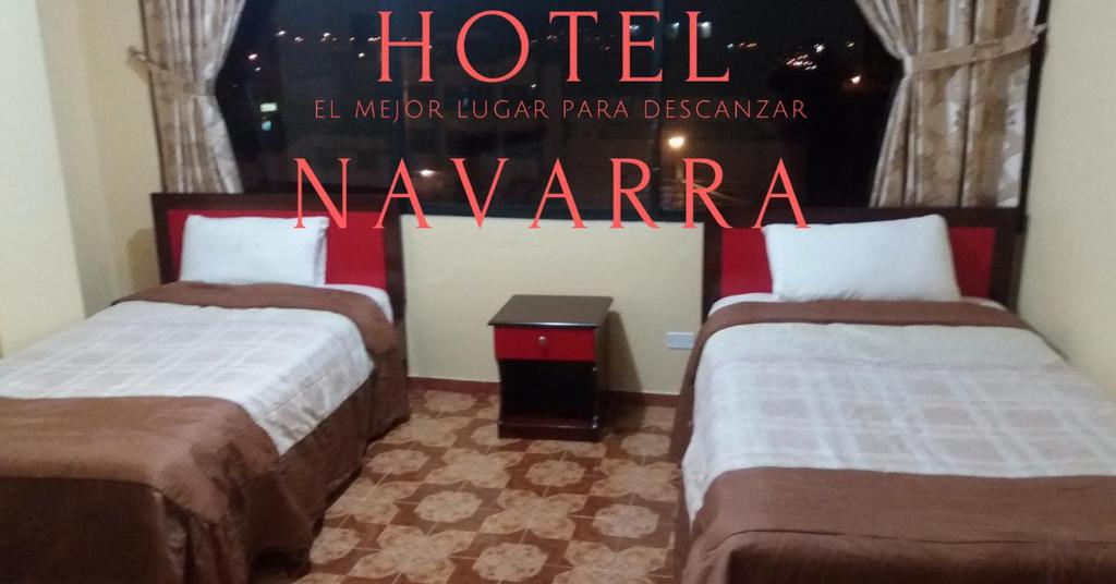 a hotel room with two beds and a sign at Hotel Navarra in Riobamba