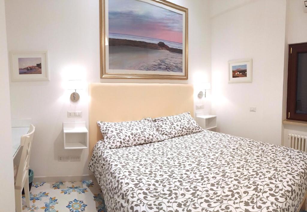ein Schlafzimmer mit einem Bett und einem Wandgemälde in der Unterkunft Mini Appartamento Al Chiostro in Neapel