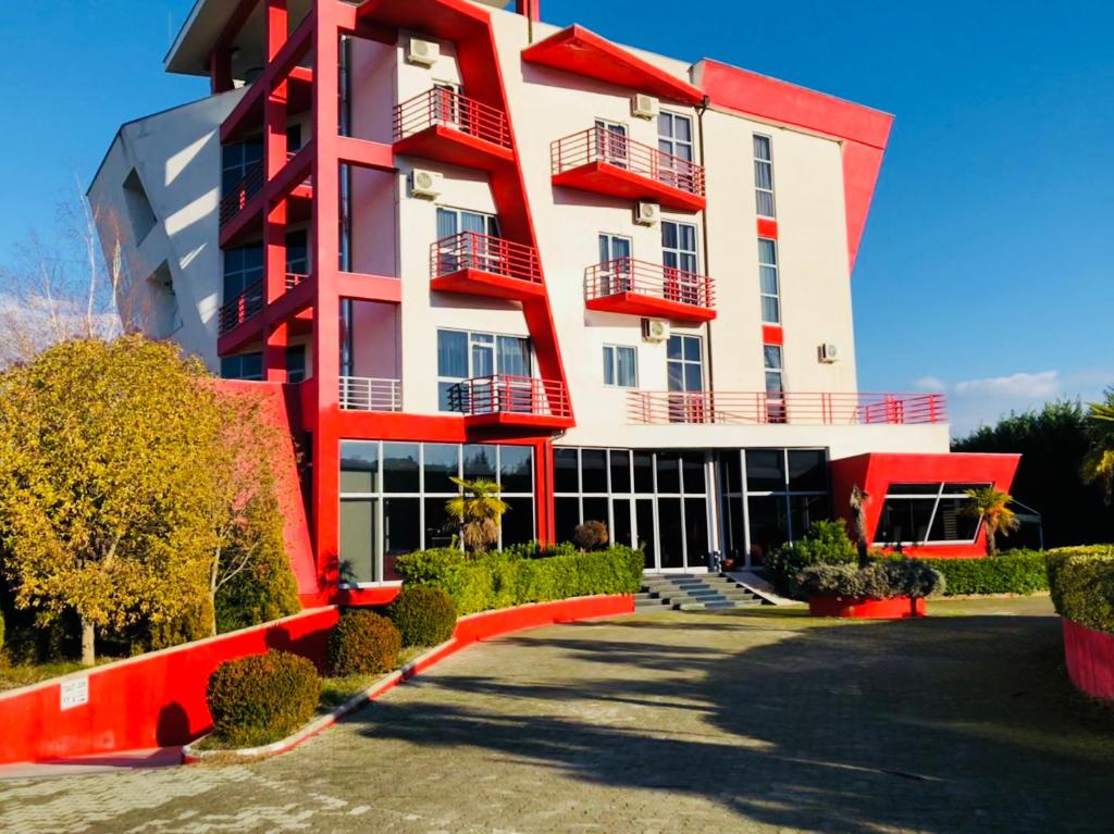 un edificio rosso e bianco con molte finestre di Hotel Class a Vorë