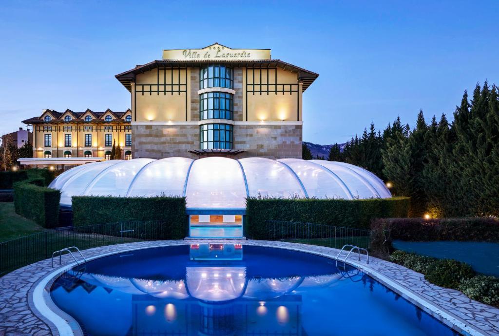 un bâtiment avec une piscine en face d'un bâtiment dans l'établissement Hotel Silken Villa de Laguardia, à Laguardia