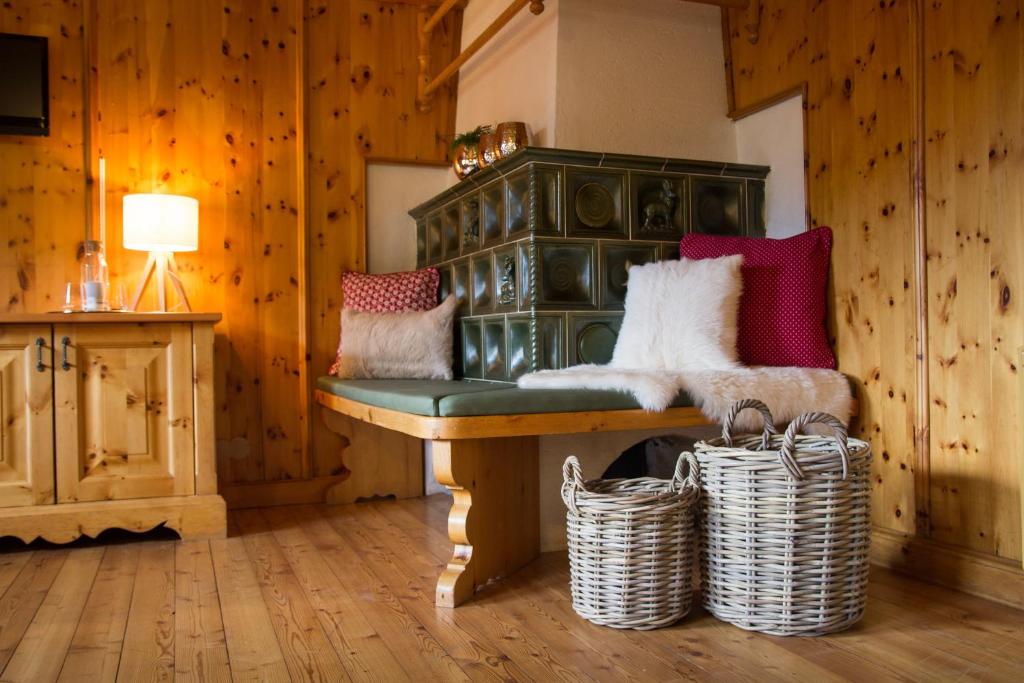 a room with a green chair with pillows and baskets at Zirbenchalet Eggriedl in Grossarl