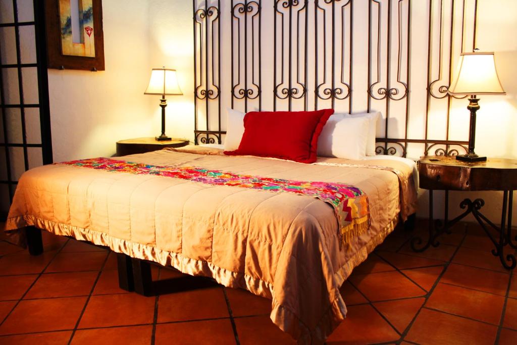 Una cama con una almohada roja en una habitación en Hotel Casa Armonia, en Guadalajara