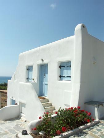 a white building with stairs and a blue door at Karades Houses Poseidon 75m2 in Naxos Chora