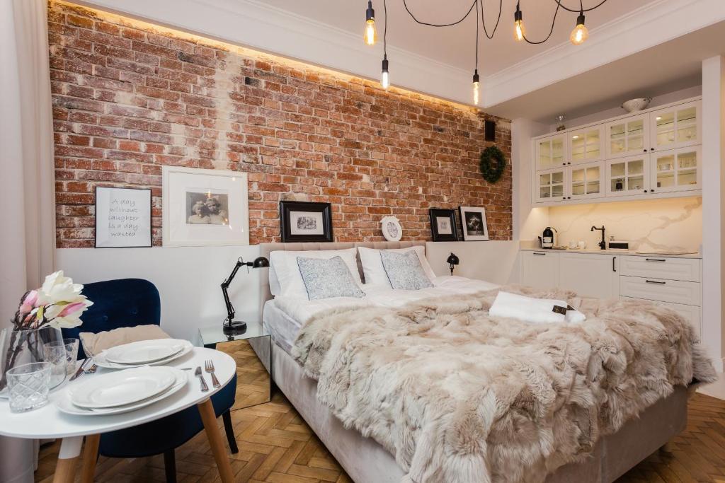 a bedroom with a large bed and a brick wall at SleepHome Poznanska in Warsaw