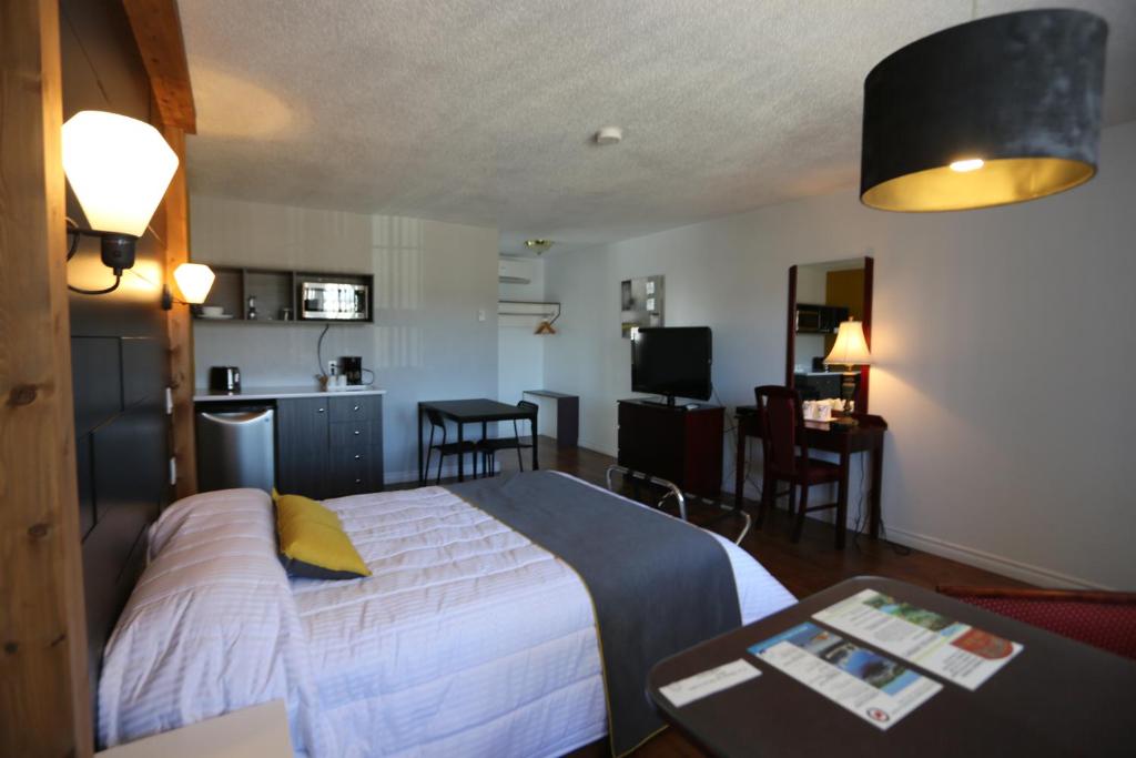 a hotel room with a bed and a kitchen at Motel Le Riviera in La Malbaie