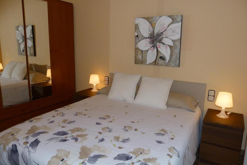 1 dormitorio con 1 cama, 2 lámparas y espejo en Ca la Xesca, en Olot