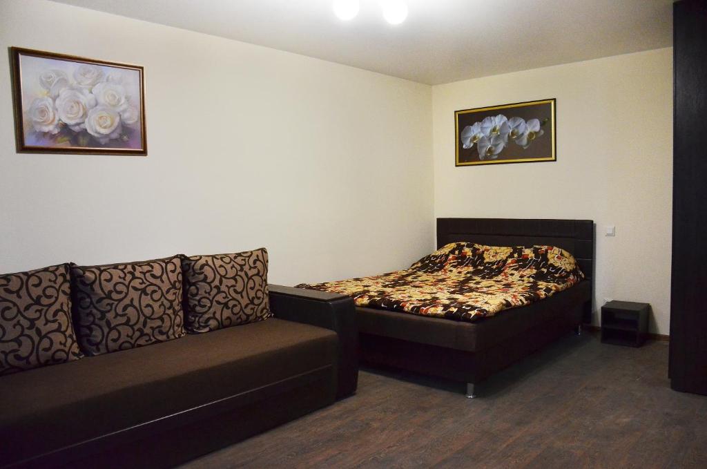ドニプロにあるАппартаменты на Алексадра Поля 115のベッドルーム(ベッド1台、ソファ付)