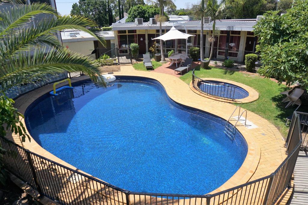 ein großer blauer Pool im Hof in der Unterkunft Jacksons Motor Inn in Adelaide