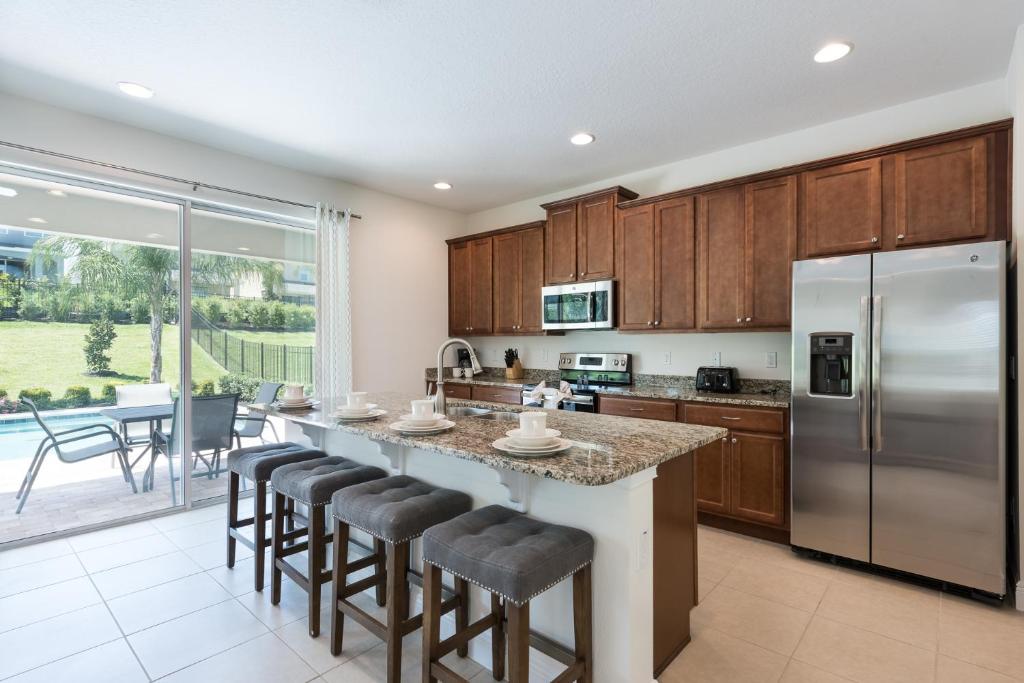 a kitchen with a large island with bar stools at New House, Ecolab Sanitzed, Near Disney, Pool Fence in Orlando