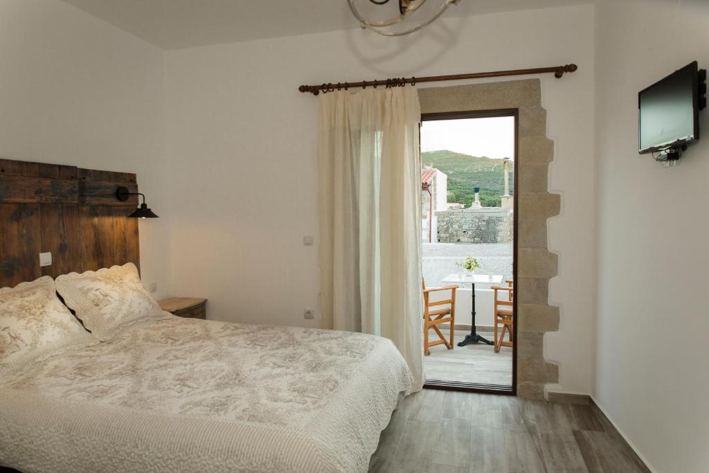 a bedroom with a bed and a door to a balcony at Aerino Villa in Azoyirás