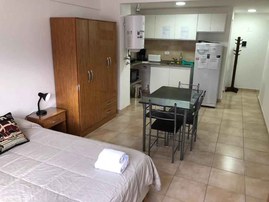 een slaapkamer met een bed en een tafel en een keuken bij Loft Rosario in Rosario