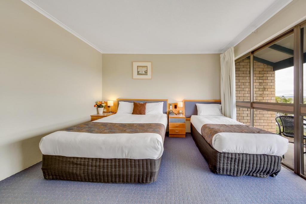 Postel nebo postele na pokoji v ubytování Gladstone Palms Motor Inn