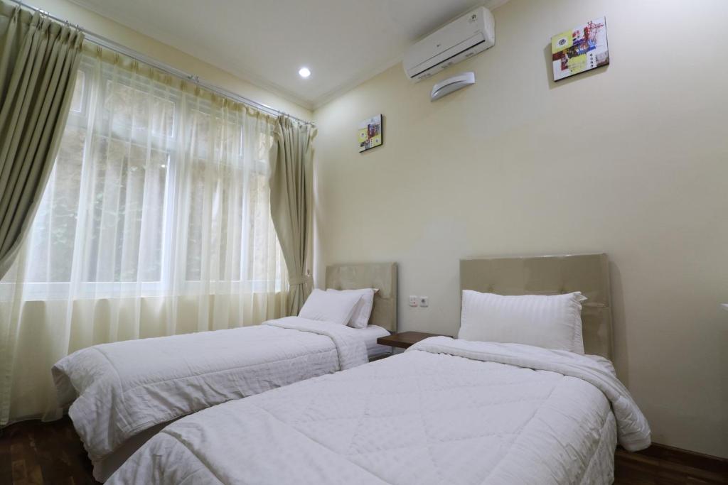 Postel nebo postele na pokoji v ubytování Diyar Villas Puncak NB3/3