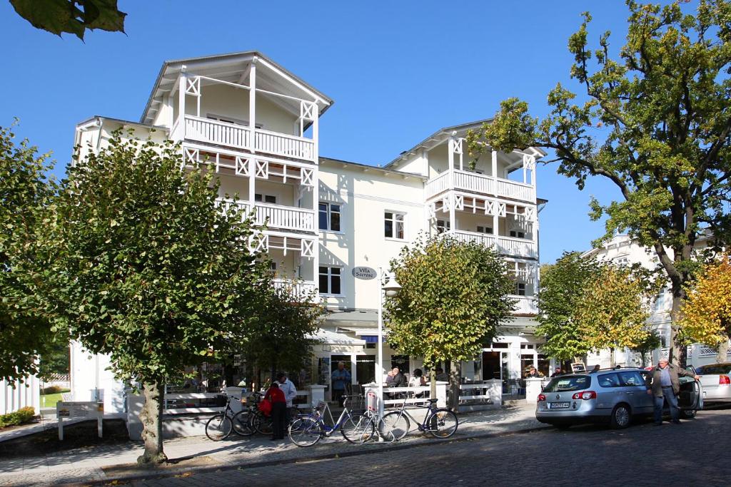 un gran edificio blanco con bicicletas estacionadas frente a él en Villa Seerose - Apt 21 Seepferdchen, en Ostseebad Sellin