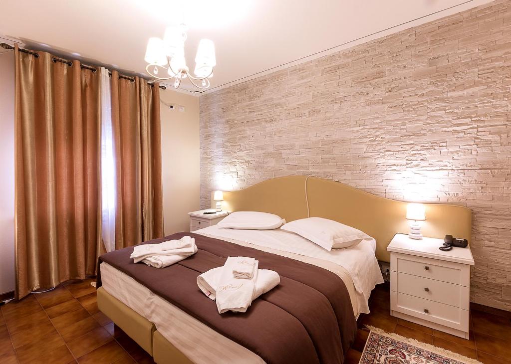 a bedroom with a large bed with towels on it at Il Novecento in Casarsa della Delizia