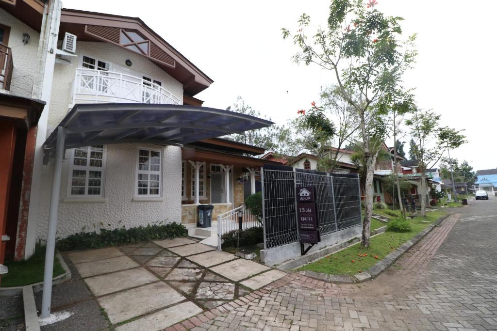 a house with an umbrella on the side of a street at Diyar Villas Puncak Q4/11 in Puncak