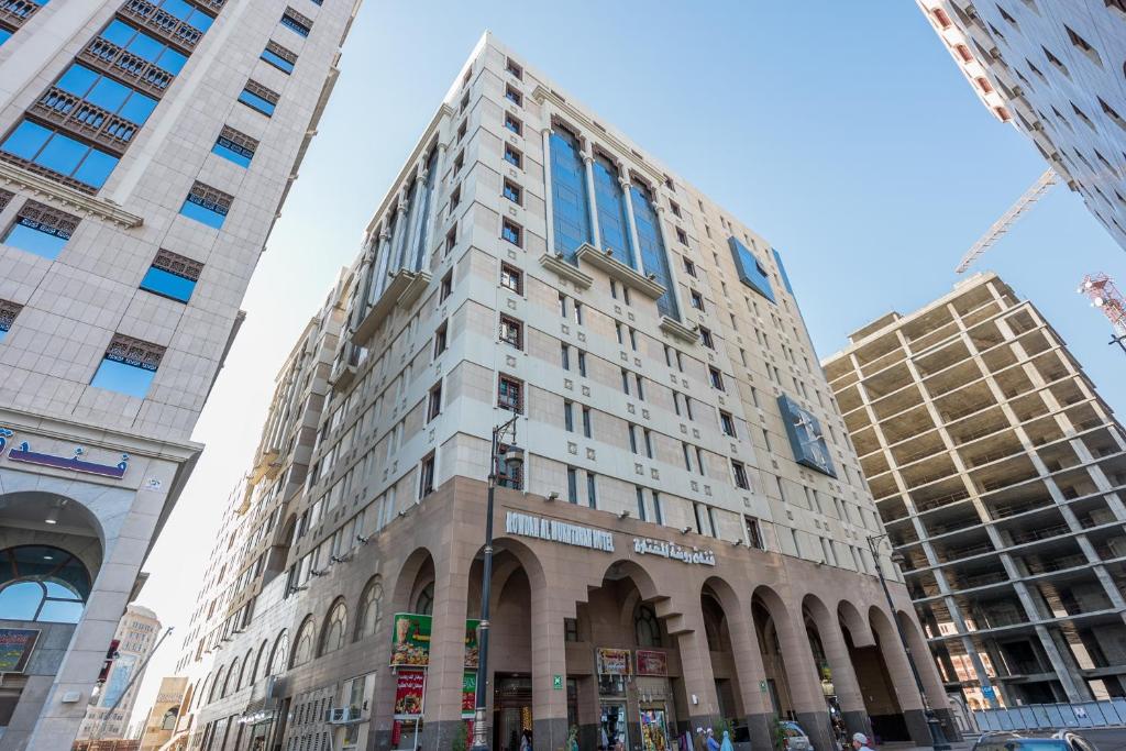 un edificio alto en medio de algunos edificios en Rawdhat Al Mukhtara Hotel, en Medina