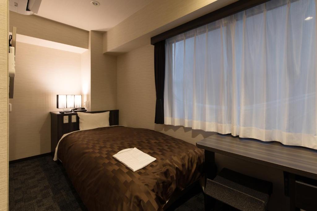 Postel nebo postele na pokoji v ubytování Hotel Taisei Nakanoshima