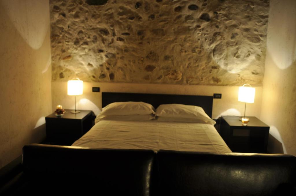 a bedroom with a bed with two lamps on both sides at Agriturismo Trebisonda Country Resort in Monzambano