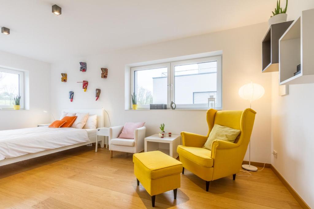 a living room with a bed and two chairs at stylish flat lux-city in Luxembourg