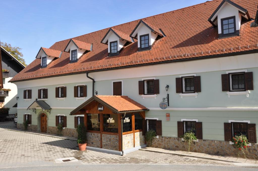 a white house with a blue roof and a white building at Bed & Breakfast Pr'Sknet in Šenčur