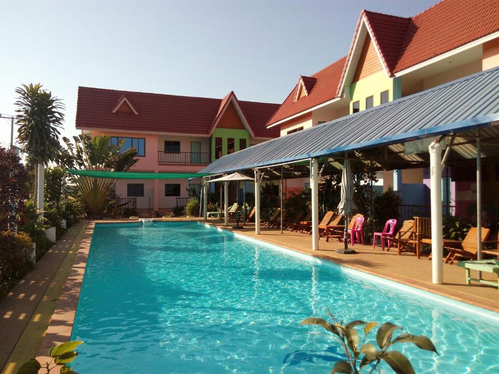 a swimming pool in front of a house at Peace Pool Resort in Khun Han