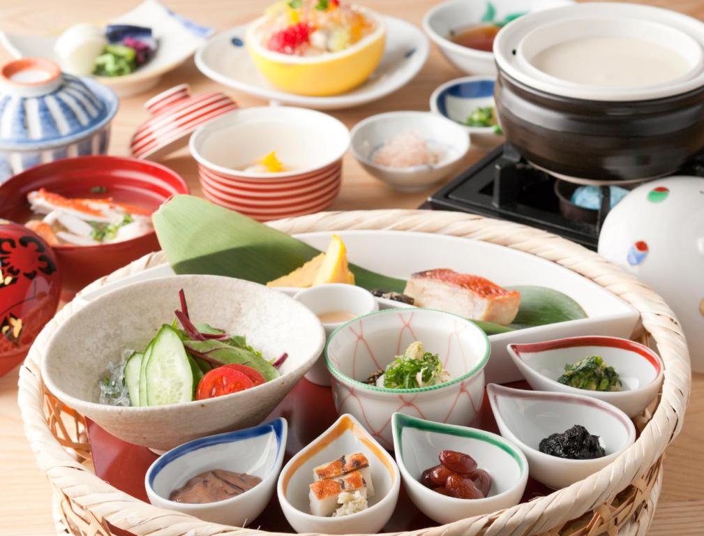 a basket filled with dishes of food on a table at Sora Togetsusoukinryu in Izu