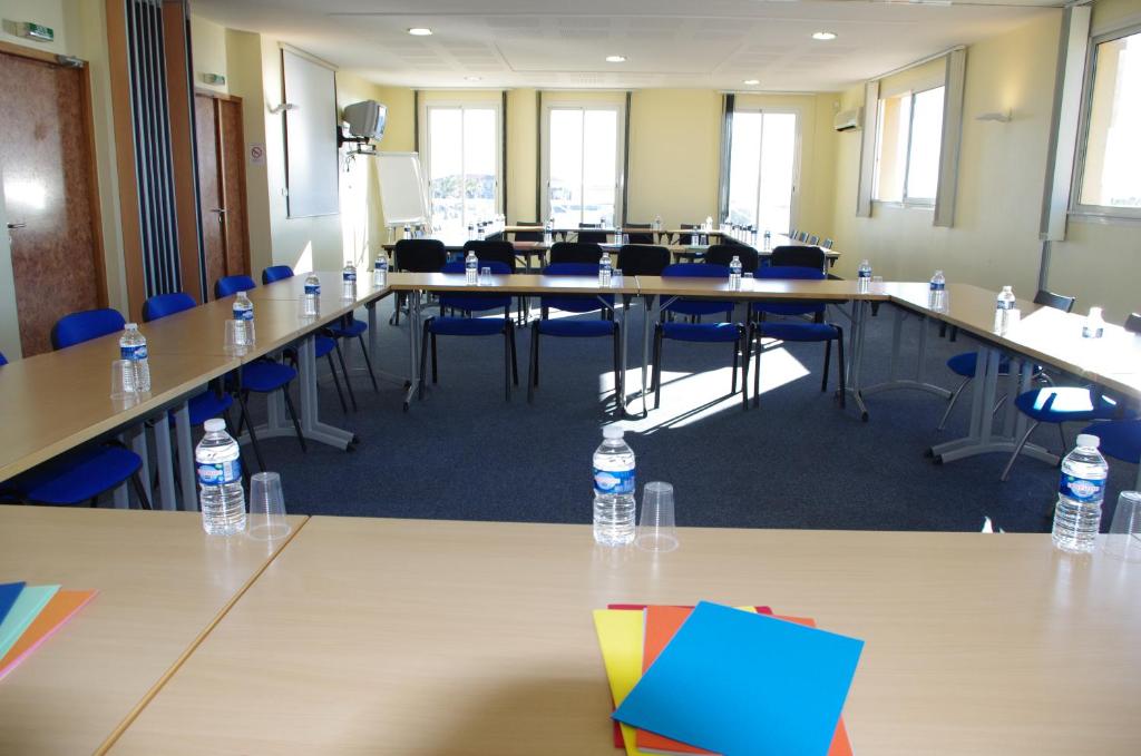 a conference room with tables and chairs and water bottles at Village Club Thalassa in Mèze