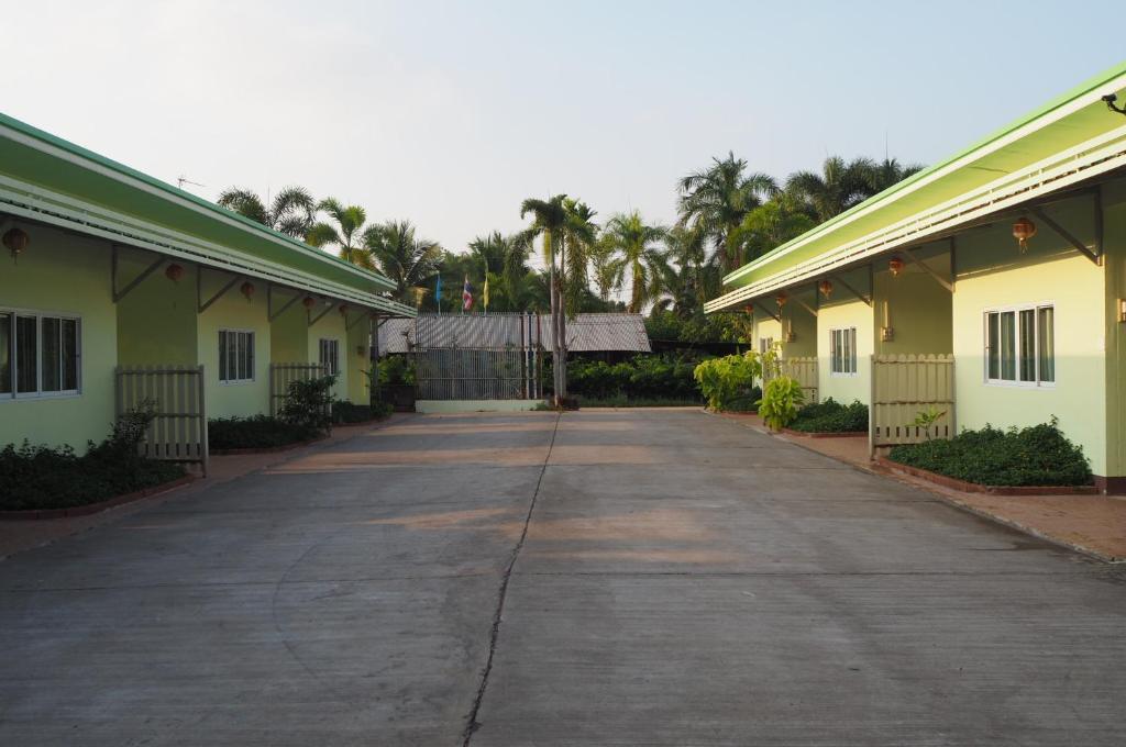 eine leere Straße zwischen zwei Gebäuden mit Palmen in der Unterkunft 555 Resort in Udon Thani