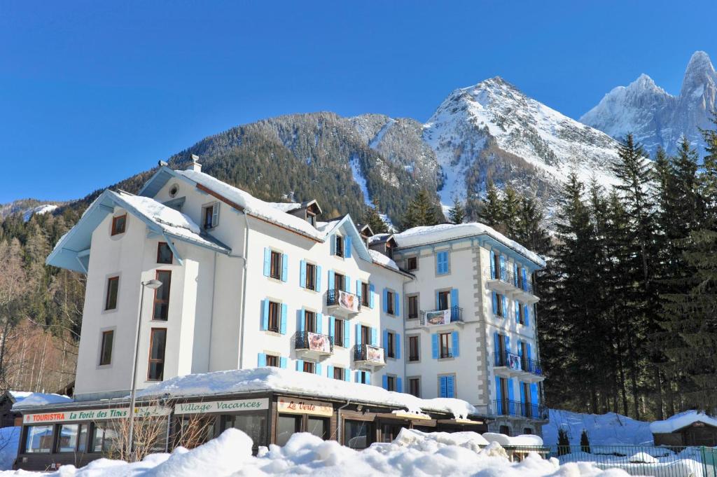 un hotel en las montañas con nieve en el suelo en Village Vacances La Forêt des Tines, en Chamonix-Mont-Blanc