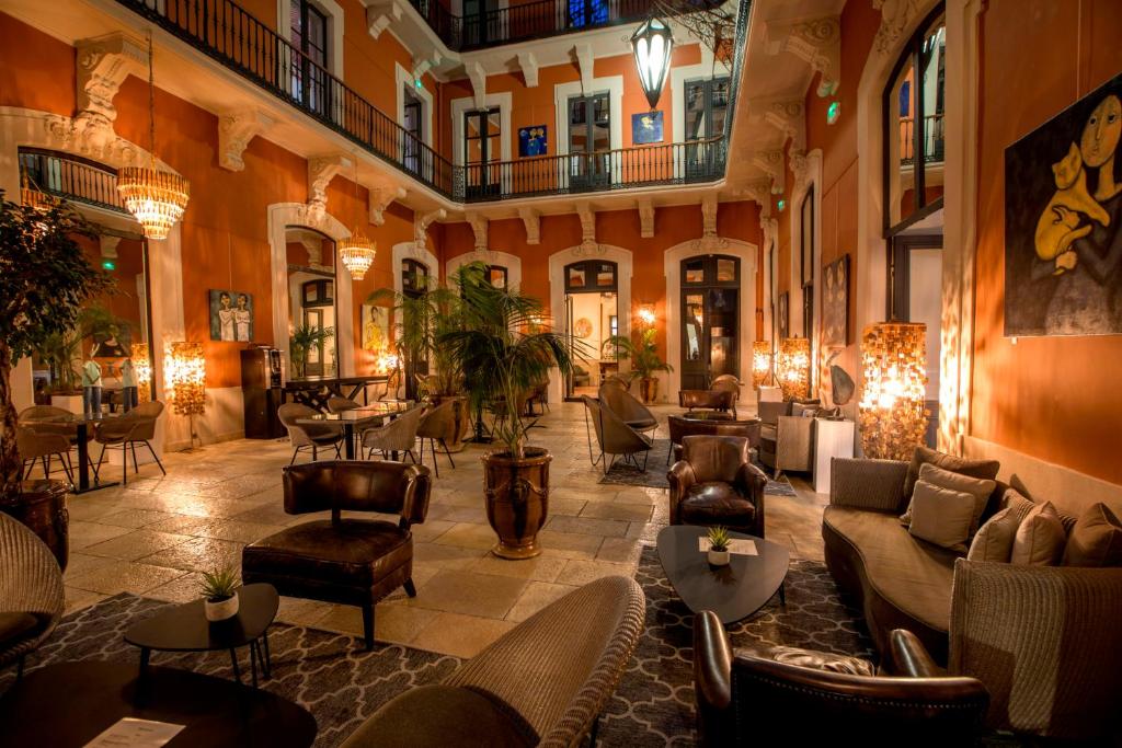 un hall avec des canapés et des chaises dans un bâtiment dans l'établissement Le Grand Hotel, à Sète