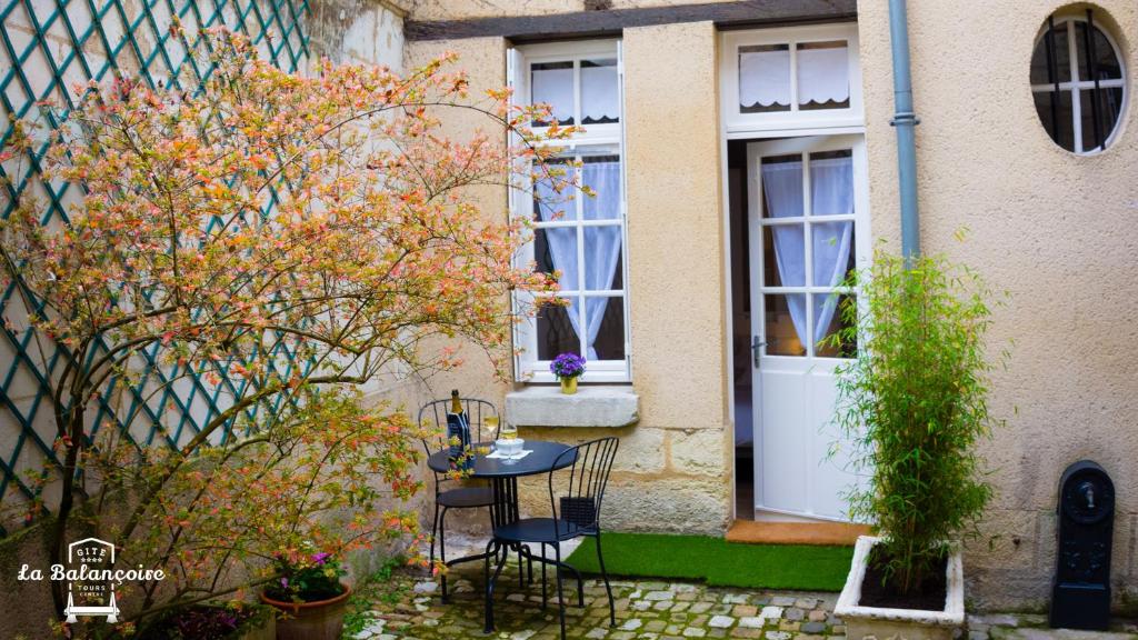 a table and chairs in front of a house at La balançoire in Tours