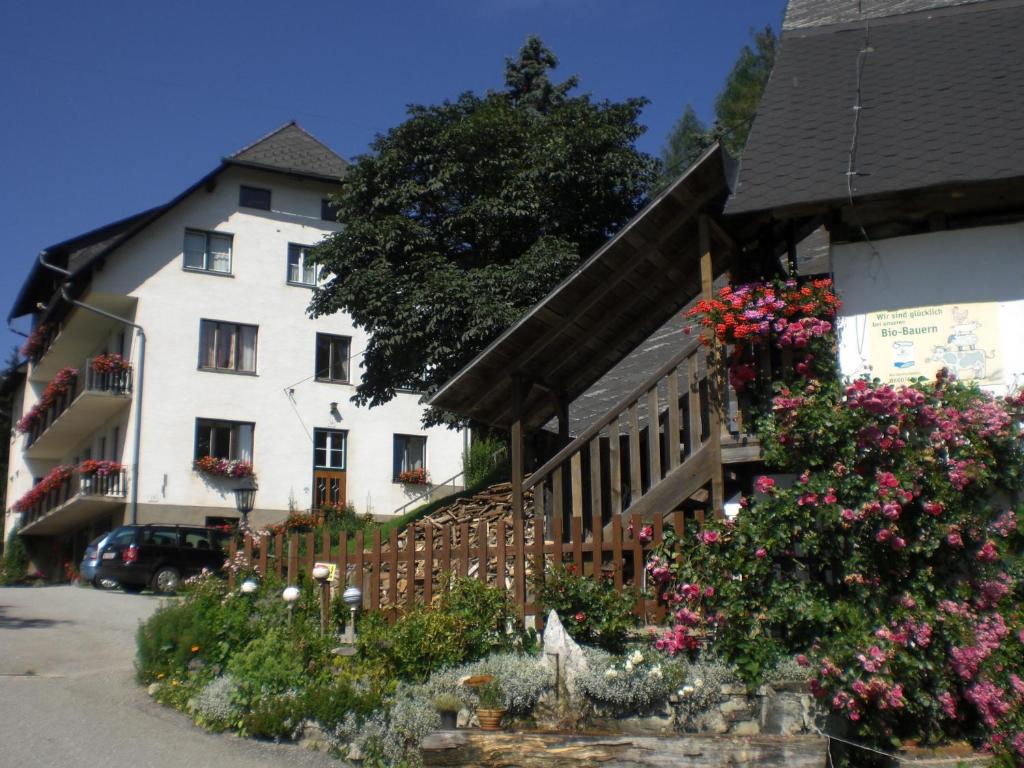 une maison blanche avec des fleurs devant elle dans l'établissement Urlaub am Bauernhof Grabenhofer, à Sankt Jakob im Walde