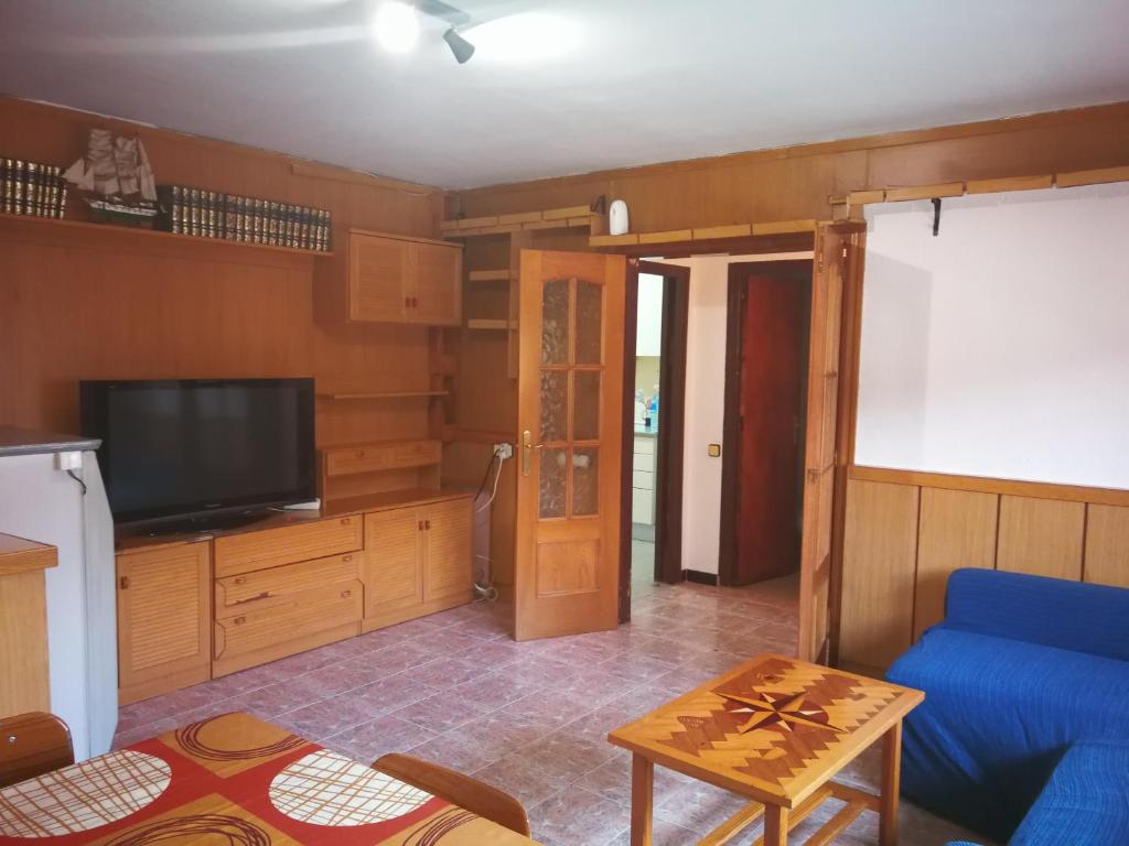 a living room with a blue couch and a tv at Holidays Domus Iano in Esparraguera