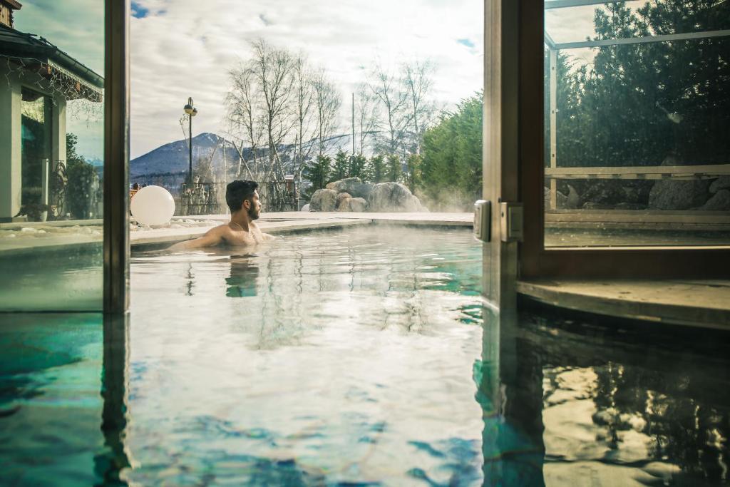 Ein Mann ist im Schwimmbad. in der Unterkunft Hotel San Giacomo Spa&Gourmet in Brentonico