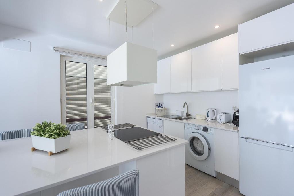 a white kitchen with a sink and a dishwasher at Marina Vilamoura Relax Apartment in Vilamoura
