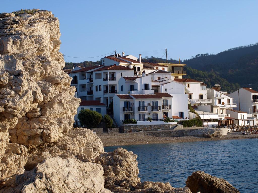 a group of buildings on the shore of a beach at Lemos Hotel in Kokkari