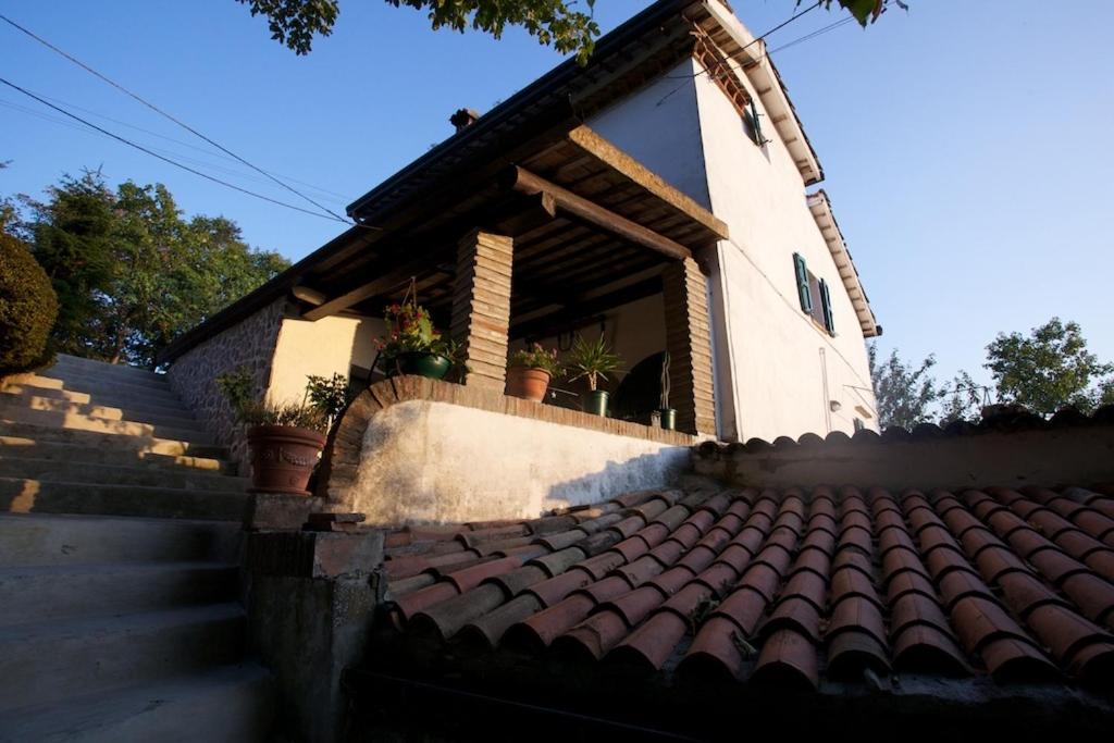 una pequeña casa con techo de baldosa y escaleras en B&B Molino Del Gobbo, en SantʼAgata Feltria