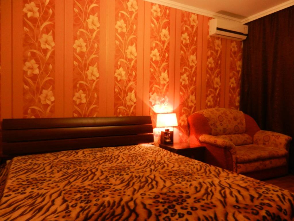 ナーベレジヌイェ・チェルヌイにあるChelny Apartments Hotelのベッドルーム1室(ベッド1台、椅子、ランプ付)
