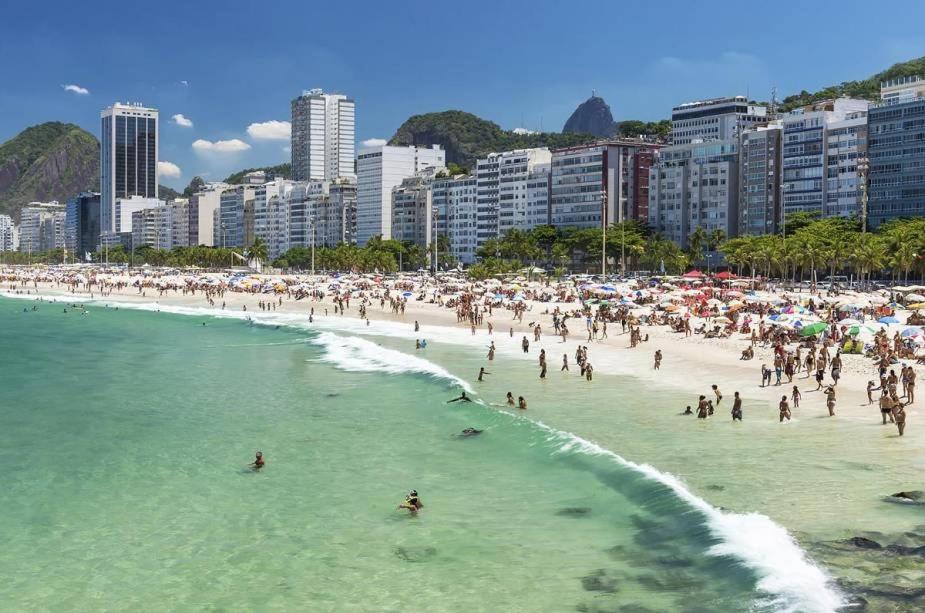 un grupo de personas en una playa en el agua en Copacabana Barata Ribeiro 135, en Río de Janeiro