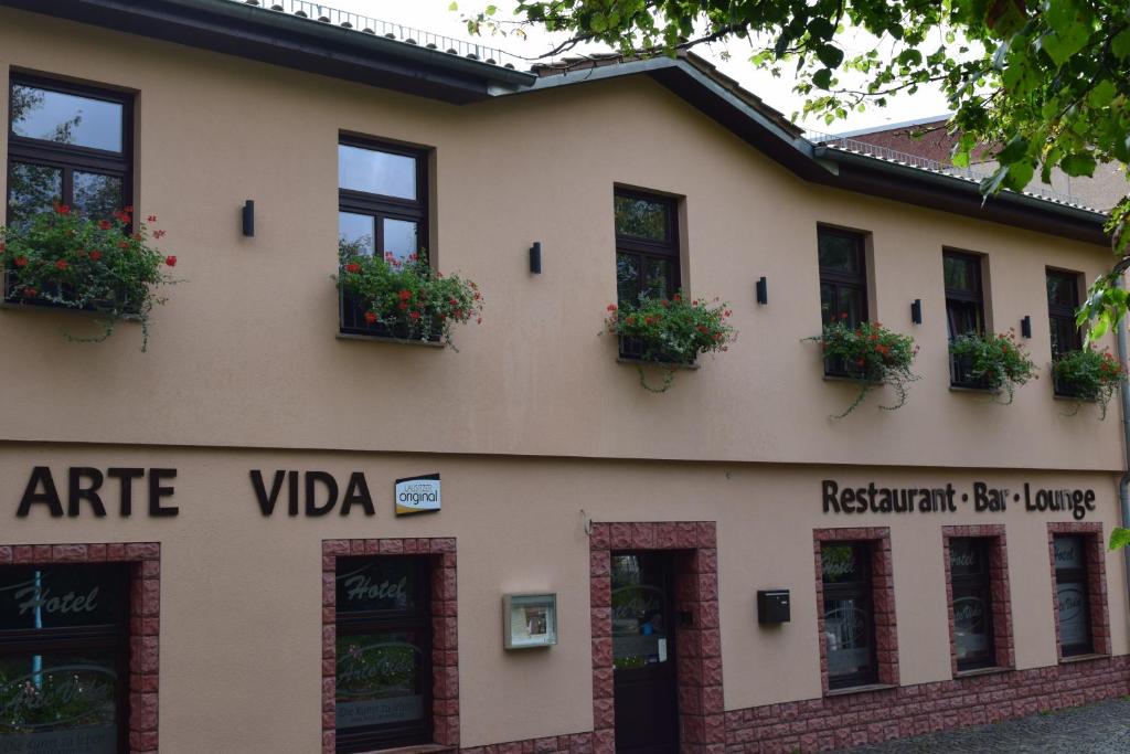 a building with potted plants on the facade at Hotel Arte Vida OHG in Spremberg